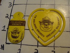 2 smokey the bear items plastic bookmark and metal item as shown